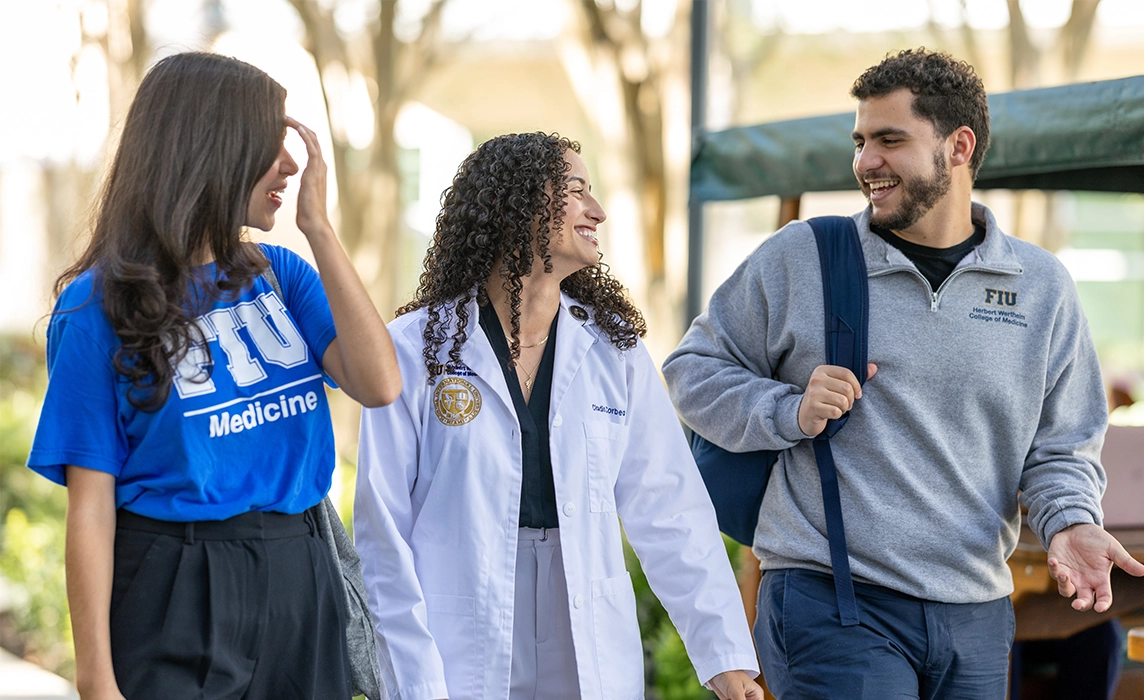 Three students talking and walking
