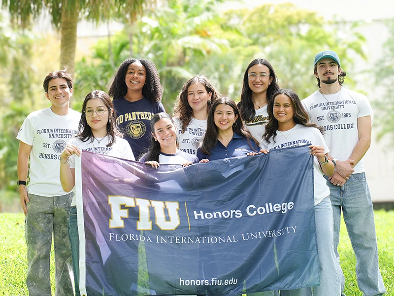 FIU Honors students posing with an Honors College banner